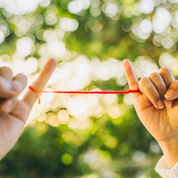 Team building innovativi: due mani legate dal filo rosso del destino