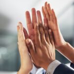 Sviluppo delle competenze: in primo piano ci sono delle persone che battono il cinque