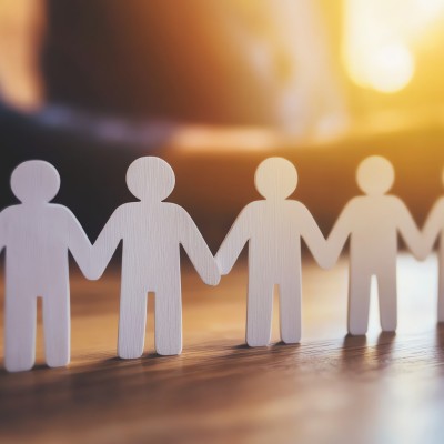 Psicologia e benssere: delle persone stilizzate si tengono per mano