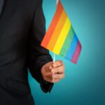 Manager tiene in mano una bandiera per il pride month