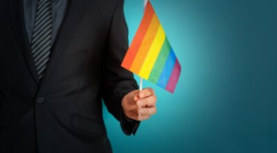 Manager tiene in mano una bandiera per il pride month