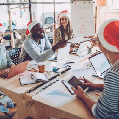 In questa immagine sono raffigurate persone che lavorano con in testa alcuni cappelli di natale